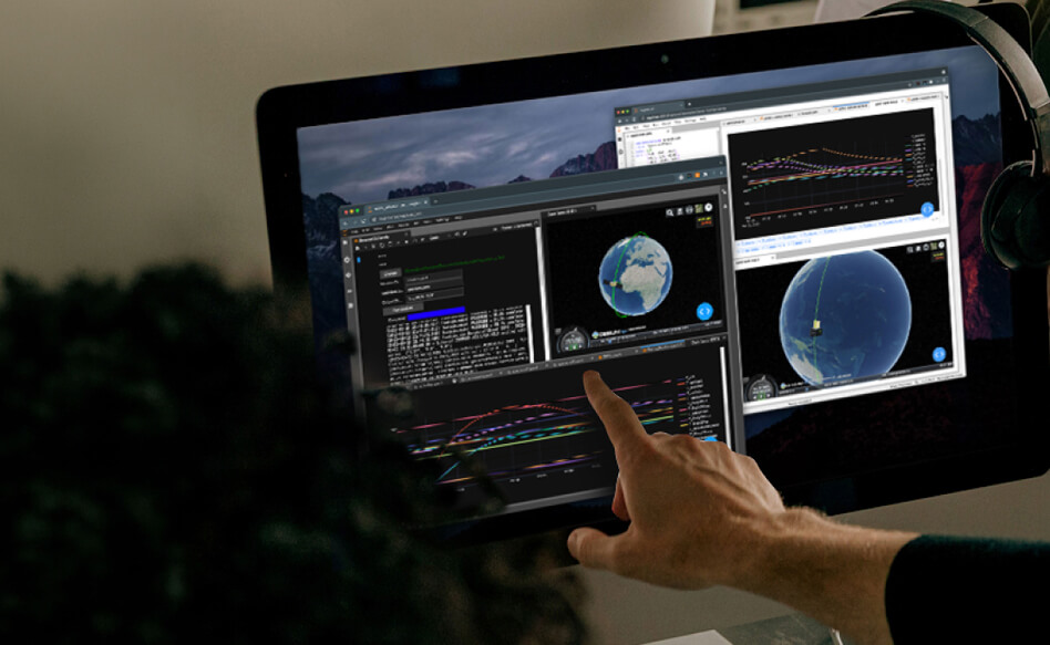 Muon-Careers-We-Build-On-a-Common-Platform-Image A hand pointing at a monitor displaying satellite tracking software with 3D globe visualizations and data graphs.