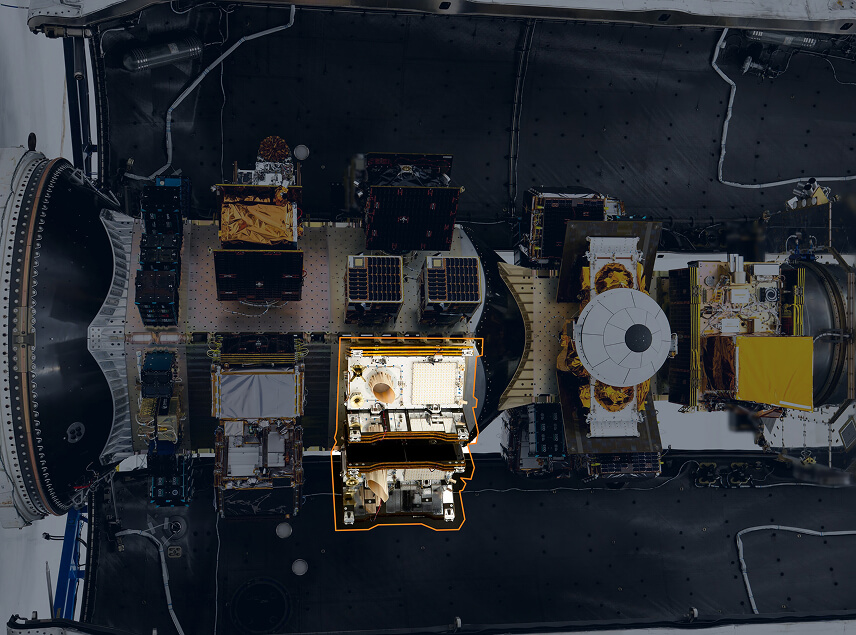 Muon Products Managed Orbital Services Horizontal Overhead view of multiple satellites and spacecraft payloads integrated inside a rocket fairing before launch.